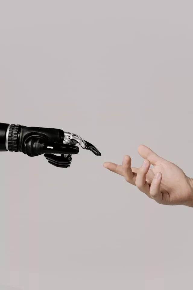 Mano humana extendida frente a una mano robótica en fondo neutro, representando la interacción entre personas y tecnología de inteligencia artificia